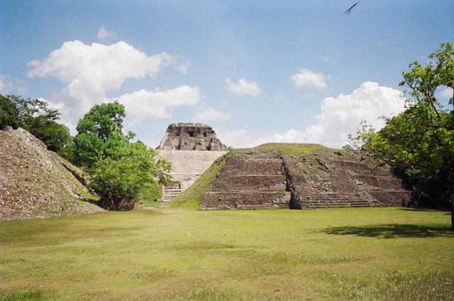 Ancient Mayan ruins set against a blue sky with scattered clouds.